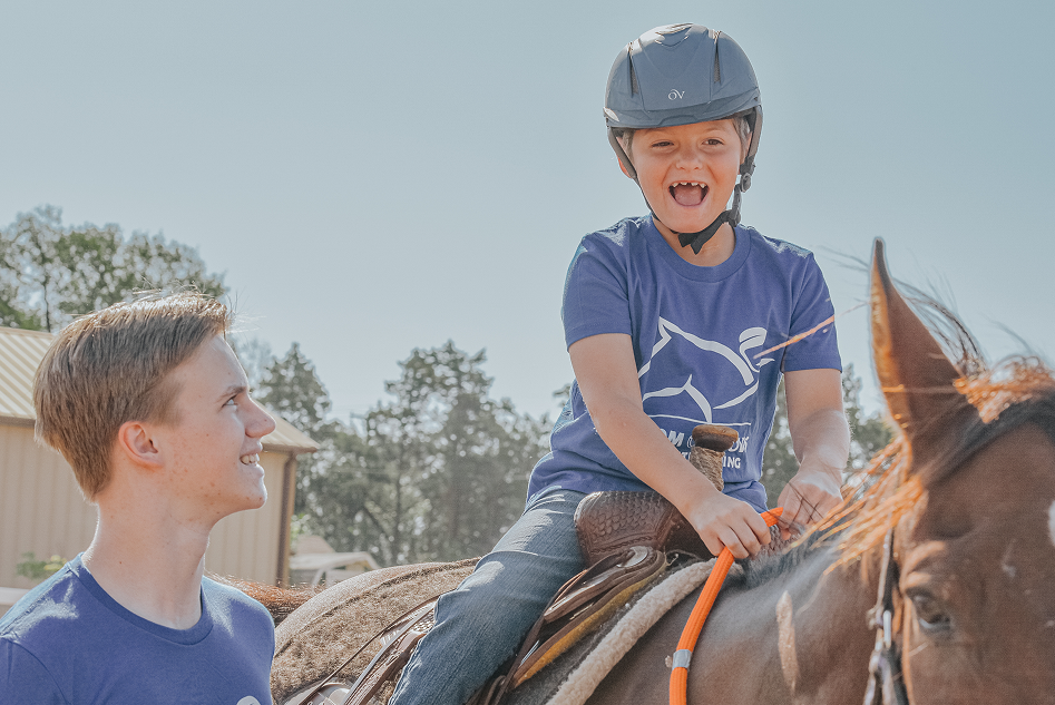 laughing boy while riding the horse