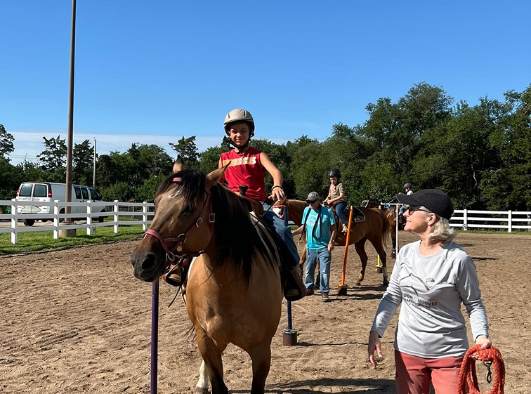 boy in red shirt riding a horse
