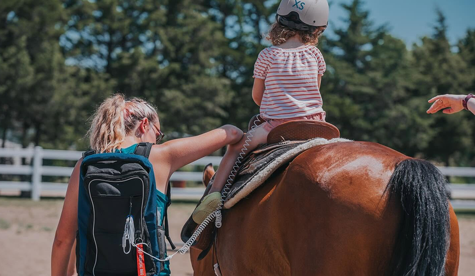 lady helping a kid to ride