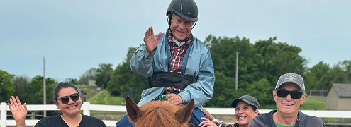 an old man wavinf while riding