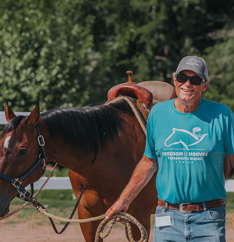 Man in blue shirt leading the horse